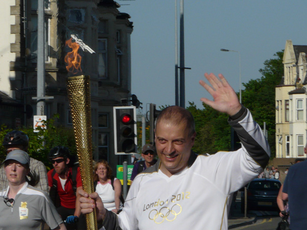 David Meek carries the Olympic Torch through Newport Road within yards of having a pint at the Club.